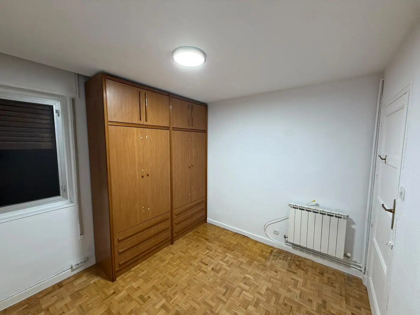 El mismo dormitorio recién pintado de blanco, limpio y con el armario en su sitio